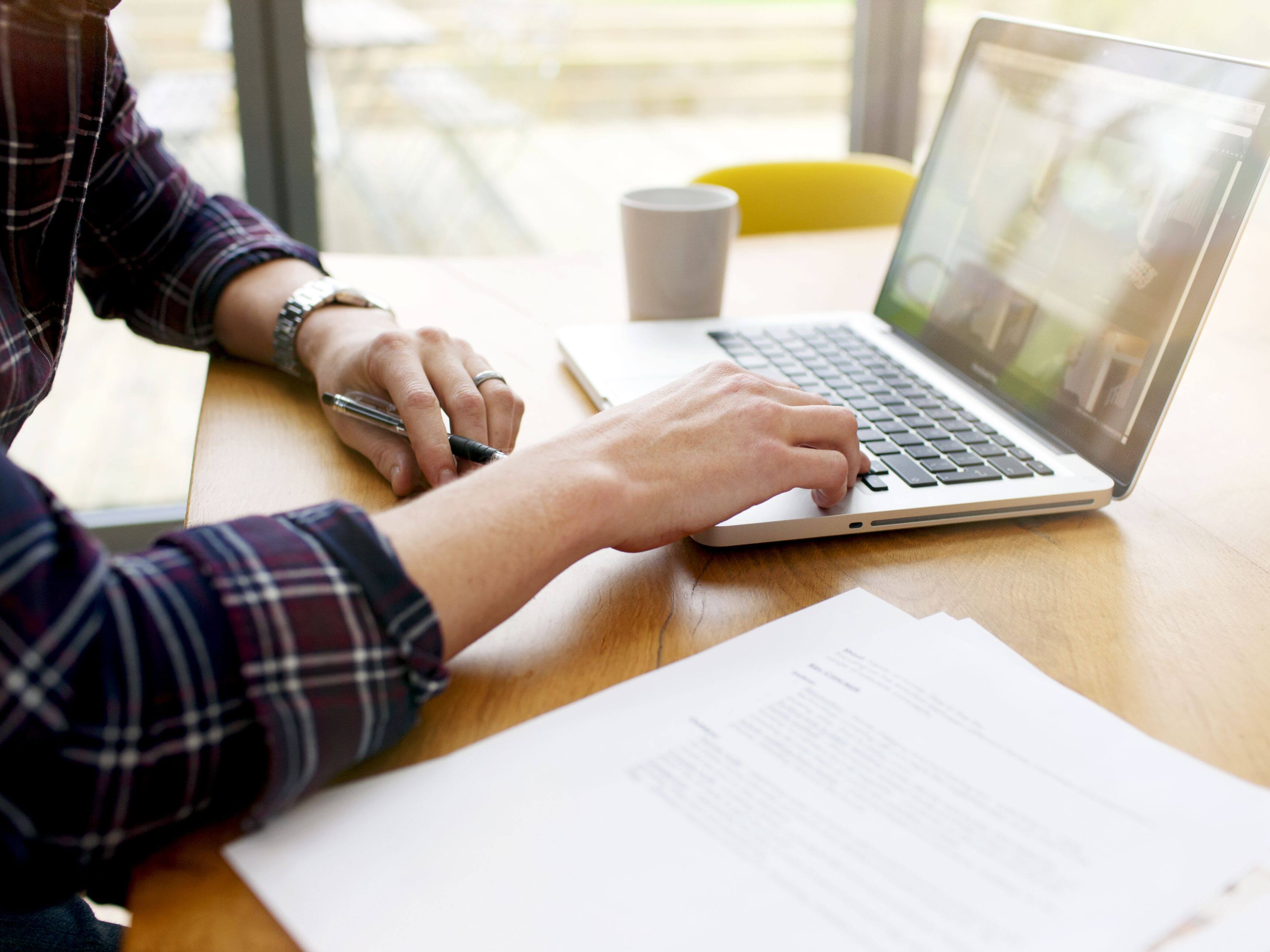 Seorang pria terlihat sedang bekerja dengan laptopnya